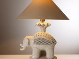 une lampe posée sur une table sur laquelle se trouve un éléphant