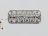 an image of a silver broochle with a bunch of diamonds on it