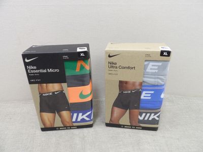 deux boîtes de sous-vêtements de sport Nike pour homme posées sur une surface blanche