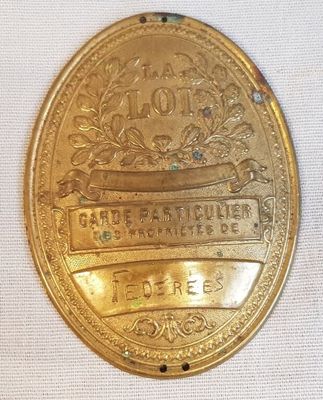 une vieille médaille d'or ornée d'un ruban, posée sur un tissu blanc