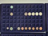 a lot of coins in a blue case on the table
