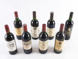 several bottles of wine are lined up on a white surface