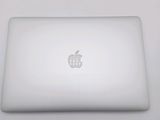 a white apple laptop sitting on a white table