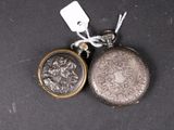 a silver pocket watch and a silver coin on a black surface