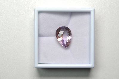 un gros plan sur un diamant rose dans une boîte blanche