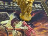a gold figurine sitting on top of a board game