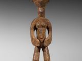 une statue en bois représentant un homme tenant un bébé dans ses bras