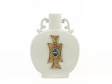 un vase blanc orné d'une croix dorée