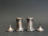 three antique pewwares are lined up on a gray surface