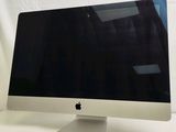 an apple computer monitor sitting on top of a white table