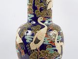 a blue vase with a design of cranes on it