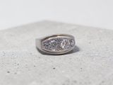 an image of a diamond ring sitting on a concrete surface