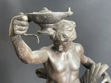 a statue of a man holding a bowl on his head