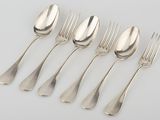 six silver spoons and a fork on a white surface