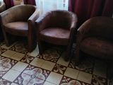 trois chaises dans une pièce aux rideaux rouges