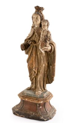 an old statue of a woman holding a child on a pedestal