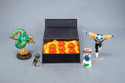 figurines de personnages de Dragon Ball dans une boîte noire posée sur une surface grise