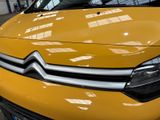 a close up of a yellow car in a showroom