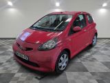 une photo d'une petite voiture rouge dans un showroom