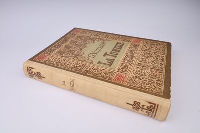 un vieux livre posé sur une table sur une surface blanche