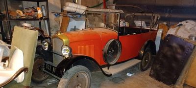 une vieille voiture qui prend la poussière dans un garage