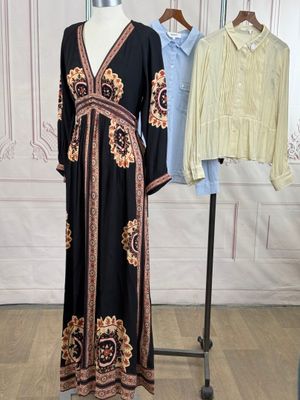 two dresses on a mannequin stand in front of a white wall