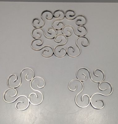 quatre morceaux de métal sont disposés en cercle sur une table