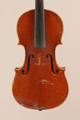 un vieux violon posé sur une surface blanche