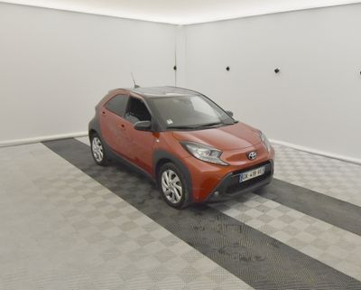 Une Toyota C-HRX orange garée dans un garage au sol à damier