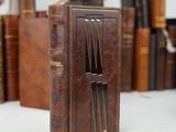 a small brown book with a clock on top of it