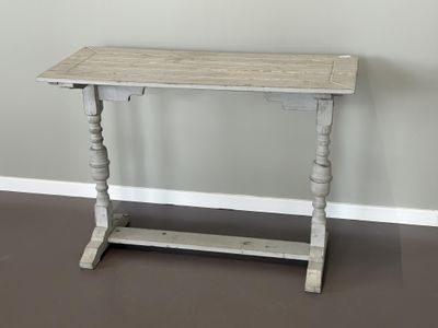 une petite table avec un plateau en bois posée sur un sol marron