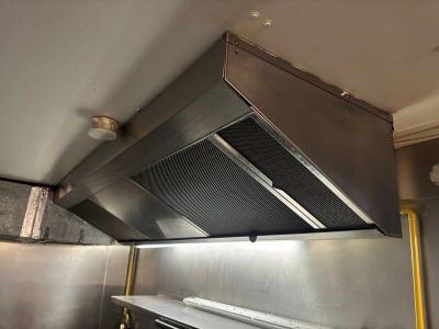 une photo d'une cuisine avec une cuisinière et une hotte aspirante