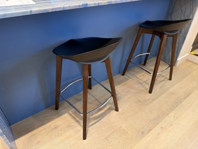 two stools that are sitting in front of a counter