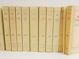 several books are lined up in a row on a white surface