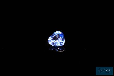 a heart shaped blue sapphire on a black background