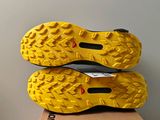 the soles of a pair of yellow shoes on top of a cardboard box