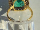 an image of a gold ring with a green stone on it