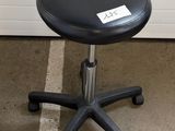 a black stool that is sitting in the corner of a room