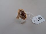 Gros plan sur une bague en or ornée d'une pierre rouge