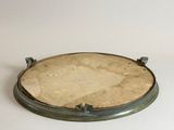 a small metal plate on a white surface with a white background
