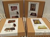 three boxes of assorted items sitting on a bed with a striped blanket