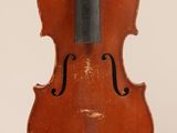 un vieux violon posé sur une surface blanche