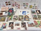 a lot of stamps and postcards on a bed