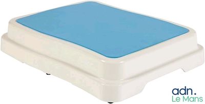 un gros plan sur un coussin bleu posé sur un socle blanc
