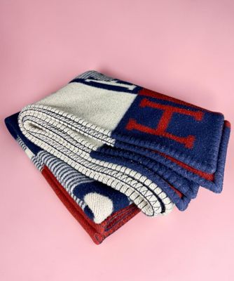 a stack of three blue and red blankets on a pink background