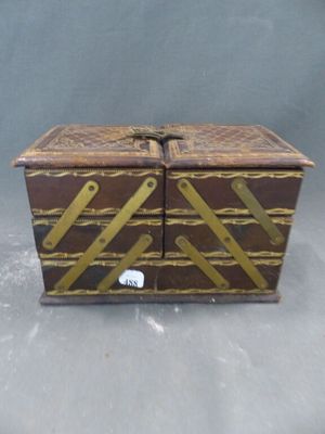 une petite boîte en bois avec un couvercle, posée sur une table