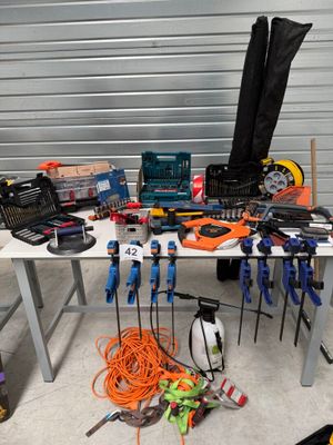 une table dans un garage, sur laquelle sont posés des outils