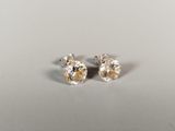 une paire de boucles d'oreilles en diamant sur une surface blanche
