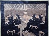 an embroidered wall hanging with a dragon and a tree on it