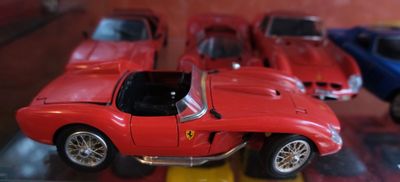 trois petites voitures exposées dans une vitrine